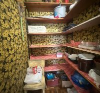 Abstellraum in einer 2-Zimmer-Wohnung mit Blumentapeten und Ablageböden.