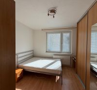 Schlafzimmer in einer 3-Zimmer-Wohnung mit Bett und Einbauschrank, Boden mit Holzdekor.