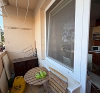 Balkon einer 3-Zimmer-Wohnung mit Holztisch und Stühlen, neben dem Küchenfenster.