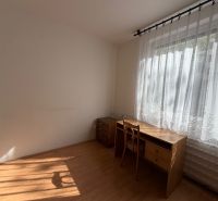 Ein Zimmer mit einem Schreibtisch und einem Stuhl, ein Boden mit Holzdekor.