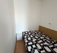 Einfaches Zimmer in einer 3-Zimmer-Wohnung mit Bett und Boden in Holzoptik.
