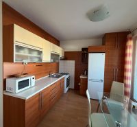 Küche in einer 3-Zimmer-Wohnung mit weißer Küchenzeile und Boden in Holzoptik.