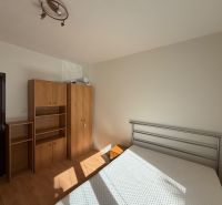 Schlafzimmer in einer 3-Zimmer-Wohnung mit weißen Wänden und einem Boden in Holzoptik.