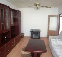 Wohnzimmer mit Holzboden, Schrank und Sofa in einer 3-Zimmer-Wohnung.