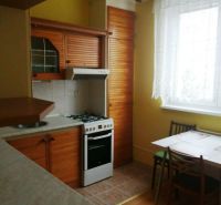 Küche in einer 3-Zimmer-Wohnung mit Holzboden, Esstisch und Herd.