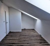 Dachboden in einem Einfamilienhaus mit Holzboden und Dachfenster.