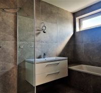 Badezimmer mit Dusche und Badewanne in einer 4-Zimmer-Wohnung.