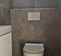 Toilette mit Keramikfliesen in einem Einfamilienhaus.