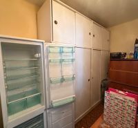 Geöffneter Kühlschrank und Einbauschränke im Zimmer einer 2-Zimmer-Wohnung.
