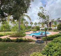 Ein von Grün und Liegestühlen umgebener Pool im Garten in Side, Türkei, für besondere Immobilien.