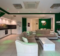 Wohnzimmer mit Sofa, Küche, Esszimmer und weißen Möbeln in einer besonderen Immobilie.