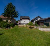 Der Garten des Einfamilienhauses in der Jahodová-Straße in Trenčín mit Rasen und Bäumen.