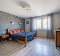 Schlafzimmer in einem Einfamilienhaus mit Holzboden, Tapete und massiven Möbeln.