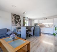 Wohnzimmer in einem Einfamilienhaus mit Küche und Holzboden.