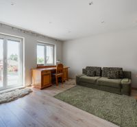 Wohnzimmer in einem Einfamilienhaus mit Holzboden, Sofa und Schreibtisch.