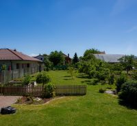 Ein Rasen-Garten bei einem Einfamilienhaus in der Jahodová-Straße in Trenčín mit Obstbäumen.