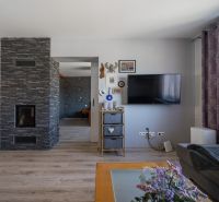 Innenraum eines Einfamilienhauses mit Fernseher, Dekorationen und Holzboden.