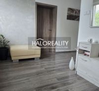 Ein Zimmer in einem Einfamilienhaus mit einem Boden in Holzoptik und moderner Einrichtung.