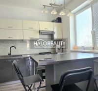 Eine Küche in einem Einfamilienhaus mit dunklen Schränken und einem Boden in Holzoptik.