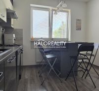 Küche in einem Einfamilienhaus mit Klappstühlen und einem Boden in Holzoptik.