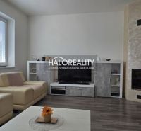 Wohnzimmer mit Kamin, Holzboden und bequemen Sofas in einem Einfamilienhaus.
