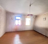 Ein leerer Raum in einem Einfamilienhaus mit Holzboden und einem Blumenleuchter.