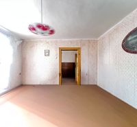 Ein Raum in einem Einfamilienhaus mit einem dekorierten Kronleuchter und einem Blumenmuster an der Wand.