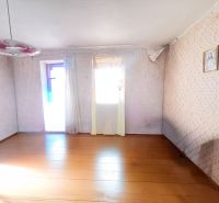 Ein Zimmer in einem Einfamilienhaus mit einem Holzboden, einem Blumenleuchter und einem Bild an der Wand.