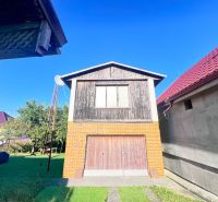 Ein Einfamilienhaus in Žirany mit einer Ziegelgarage und Holzelementen im Garten.
