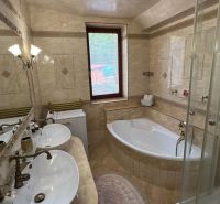 Badezimmer in der Villa mit Badewanne, Dusche und Doppelwaschbecken.