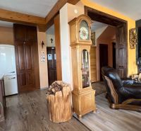 Innenraum der Villa mit Holzboden, antiker Uhr und Kamin.