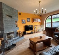 Wohnzimmer in einer Villa mit Kamin, Holzboden und Ledermöbeln.