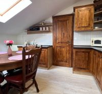 Küche in der Villa mit Holzschränken, Esstisch und Boden mit Holzdekor.