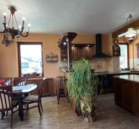 Holzmöbel in der Küche mit einem Boden in Holzoptik und einem großen Fenster.