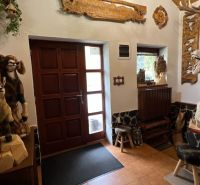 Das Innere der Villa mit hölzernen Tierskulpturen und geschnitzten Verzierungen an den Wänden.