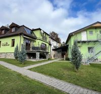 Eine Villa in Štôla, Bezirk Poprad, Region Prešov, mit einer bunten Fassade und einem Garten.