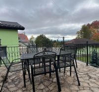 Terrasse der Villa in Štôla, Bezirk Poprad, Region Prešov, mit einem Tisch und Metallstühlen.