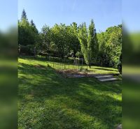 Garten bei einem Einfamilienhaus in Horné Otrokovce, grüner Rasen und Obstbäume.