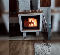 In einem Einfamilienhaus befindet sich ein Kamin auf einem Boden mit Holzdekor.