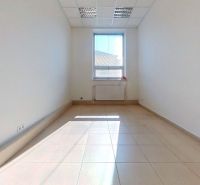 Ein klares Büro mit gefliestem Boden und einem großen Fenster, das Licht hereinlässt.