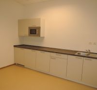 Küchenzeile mit eingebauter Mikrowelle und Spüle im Büro.