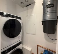 Waschküche im Einfamilienhaus: Waschmaschine, Trockner, Zentralstaubsauger BEAM und Wasserfilter.