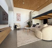 Wohnzimmer in einem Einfamilienhaus mit bequemer Couch und dekorativen Bildern an der Wand.