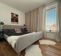 Schlafzimmer mit Bett, Vorhängen, Bild und Boden mit Holzdekor in einem Einfamilienhaus.