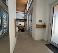 Eingangsflur in einem Einfamilienhaus mit großen Fenstern und Oberlichtern.