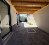 Ein Einfamilienhaus in Piešťany am Orviský kút mit einer eingelassenen Terrasse und Pflastersteinen.