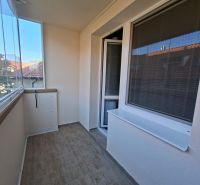 Veranda mit Verglasung in einer 3-Zimmer-Wohnung, Fliesen in Holzoptik, angenehme Belichtung.