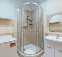 Badezimmer mit Dusche, Waschmaschine und Waschbecken in einer 3-Zimmer-Wohnung.