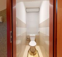 Toilette in einer 3-Zimmer-Wohnung mit kombinierter Fliese und Rollladenfenster.