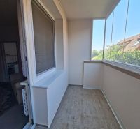 Veranda mit Glas und Fliesen in einer 3-Zimmer-Wohnung, neben Wohnräumen.
